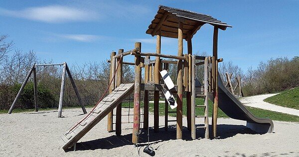 a playground structure in a park with a blue sky background