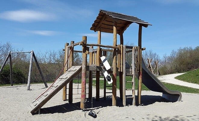 a playground structure in a park with a blue sky background