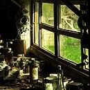 A workbench full of junk next to an old window