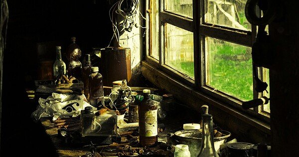 A workbench full of junk next to an old window