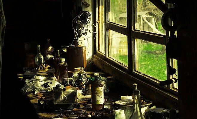 A workbench full of junk next to an old window