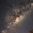 A shooting star streaks across the bright stars outlining the disk of the Milky Way