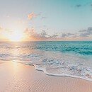 View of a calm beach with the sun at the horizon