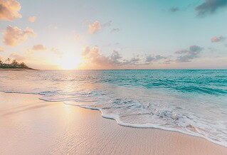 View of a calm beach with the sun at the horizon