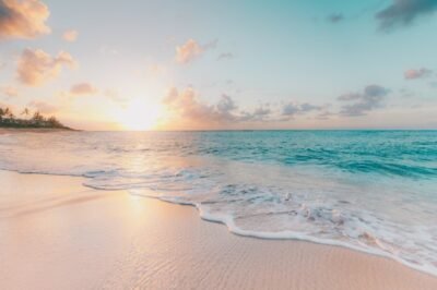 View of a calm beach with the sun at the horizon