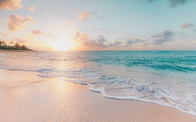 View of a calm beach with the sun at the horizon