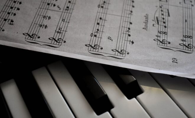 There is a piano shown in the image along with a music sheet that lies slightly atop the piano, faint shadows shown underneath the paper as well.