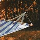 a blue and white cloth hammock in the setting sun