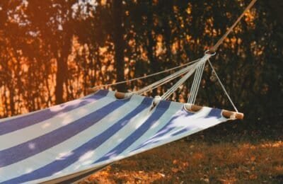 a blue and white cloth hammock in the setting sun