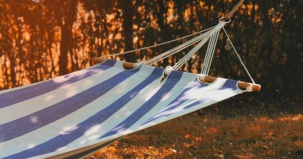 a blue and white cloth hammock in the setting sun