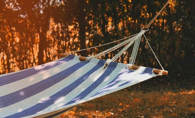 a blue and white cloth hammock in the setting sun
