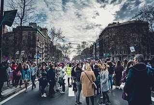 women gathered in the street with buildings around them