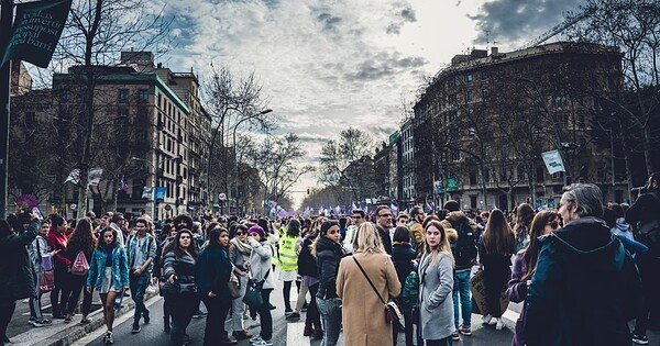 women gathered in the street with buildings around them