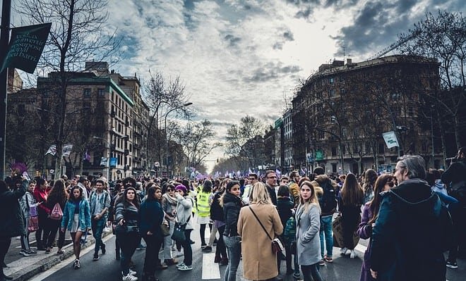women gathered in the street with buildings around them