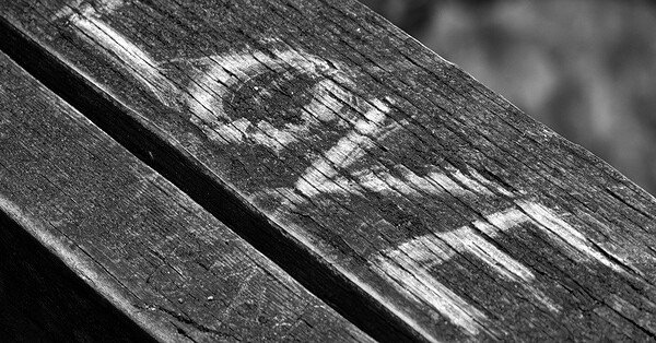 A black and white background with the words "I love" etched into a piece of wood.