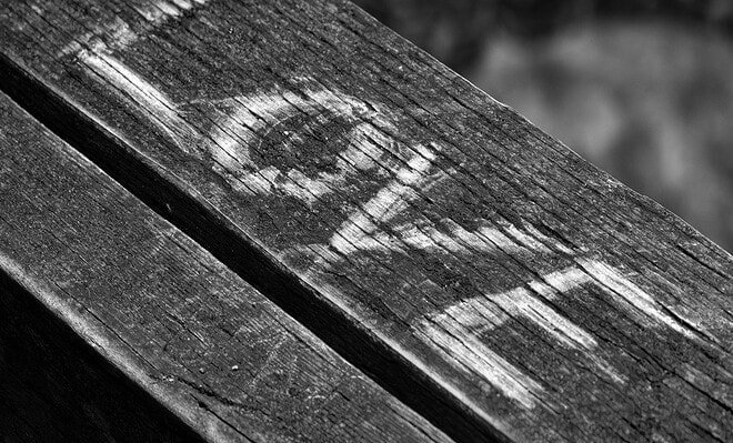 A black and white background with the words "I love" etched into a piece of wood.