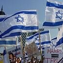 Israel flags being held by people with Hamas protest signs