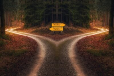 A crossroad with opposing signs in a wooded area