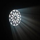 Light shining through a circular window into a dark room.