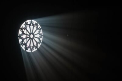 Light shining through a circular window into a dark room.