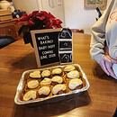 Pregnancy announcement showing a batch of cinnamon rolls with a couple holding her pregnant belly
