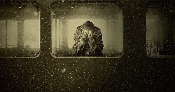 A woman crying in a train compartment car