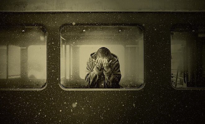 A woman crying in a train compartment car